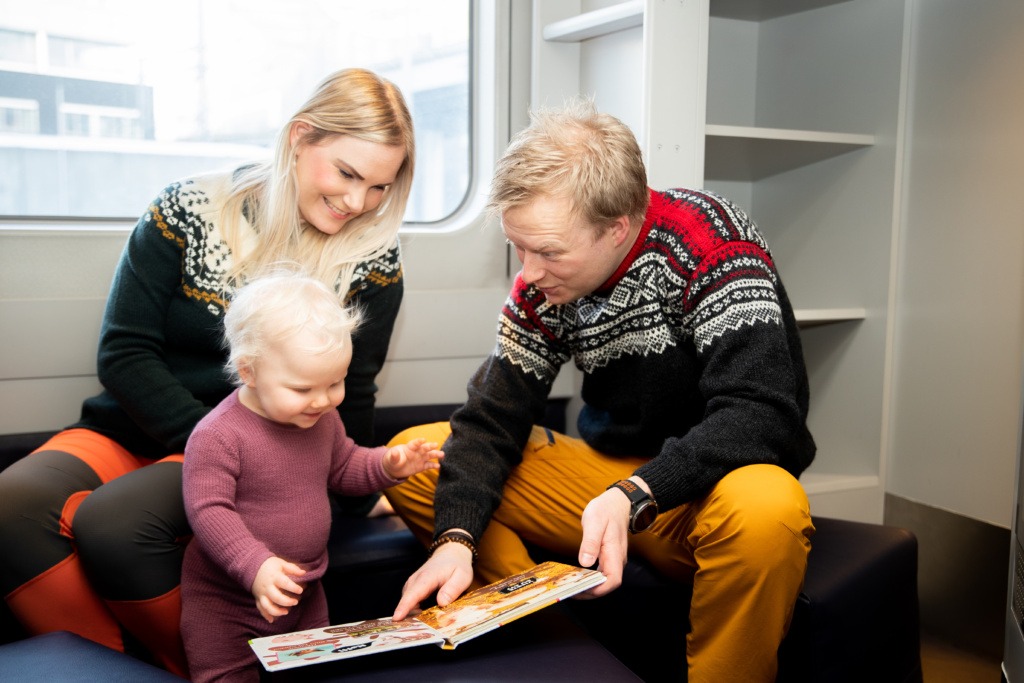 Far, mor og baby sitter på lekerom i Familievogna